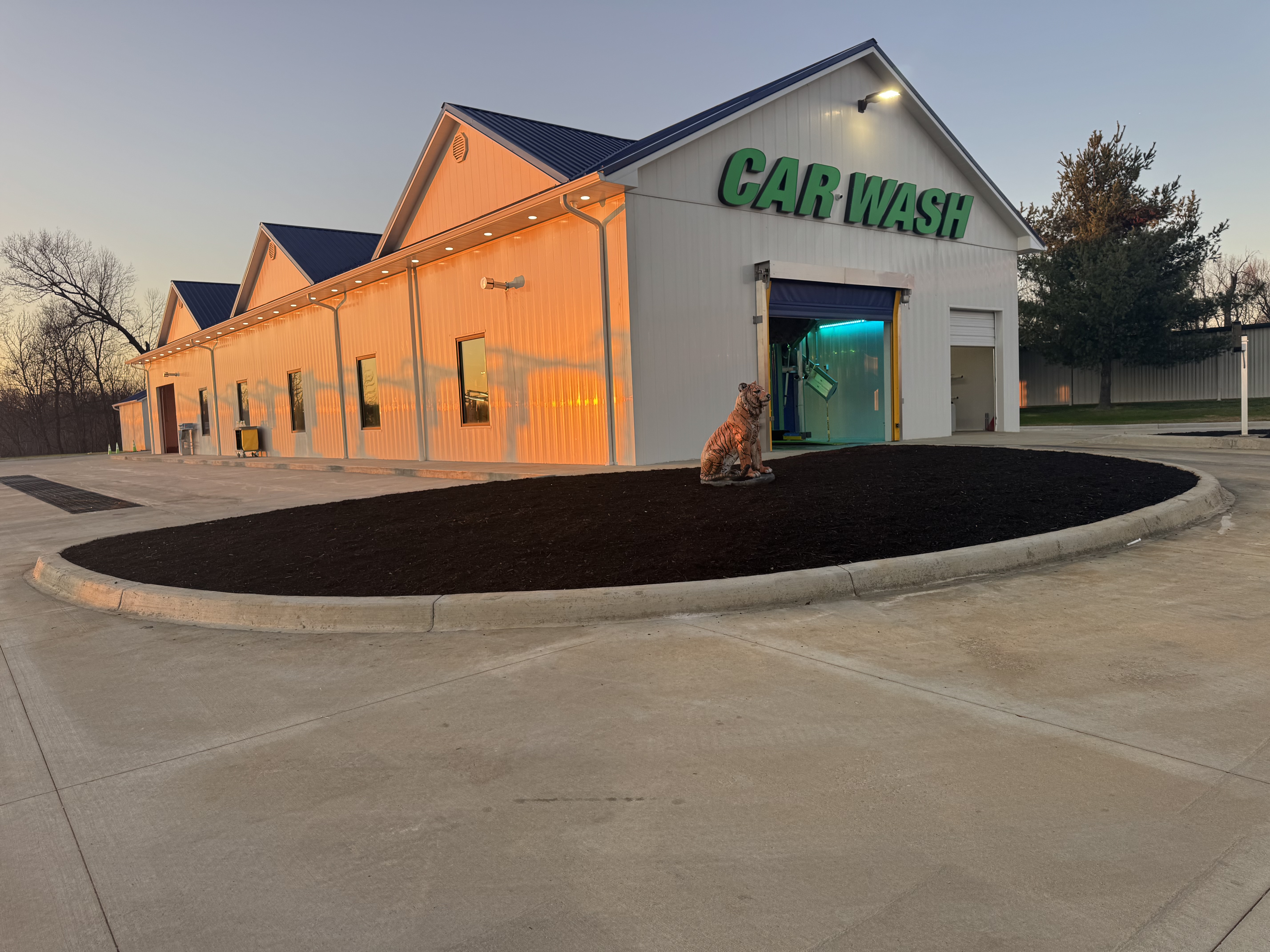 Jungle Jim's Express Car Wash building exterior at dusk with the tunnel entrance lit up, Bardstown, KY